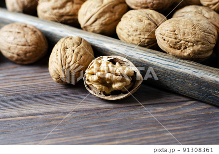 Walnuts on a dark brown wooden background. Close up. Selective focus, side view. Copy space. Walnuts on a dark brown wooden background. Close up. Selective focus, side view. Copy space. 91308361