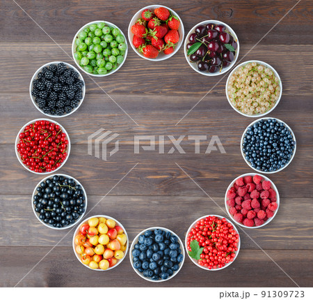 A set of berries in the round plates. Brown wooden background. Copy space. Flat top view 91309723