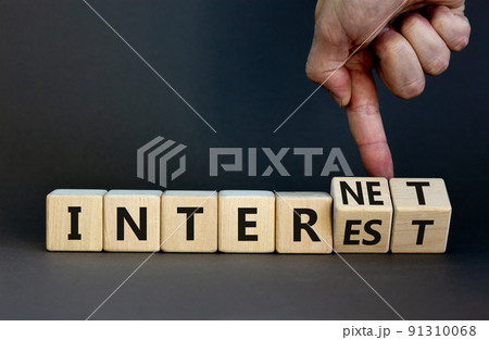 Internet and interest symbol. Businessman turns wooden cubes and changes the words interest to internet. Beautiful grey background. Copy space. Business, internet and interest concept. 91310068