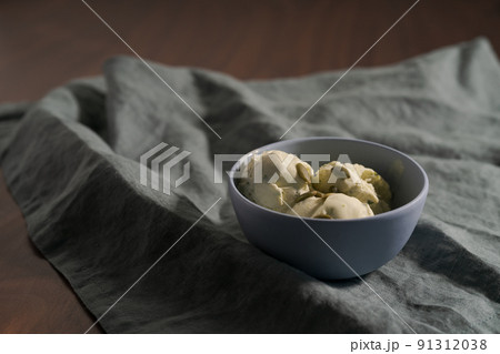 Pistachio ice cream with pumpkin seeds in bowl on table 91312038