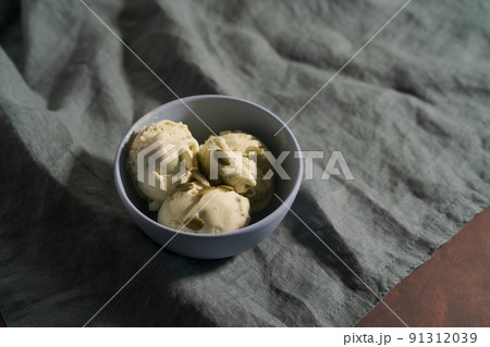 Pistachio ice cream with pumpkin seeds in bowl on table 91312039