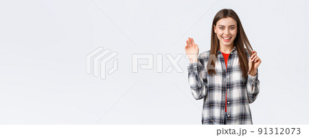 Lifestyle, different emotions, leisure activities concept. Friendly attractive young woman saying hi or bye, waving hand in greeting with happy enthusiastic smile, meeting fellow students 91312073