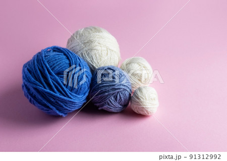 Blue and white knitted wool on a pink background for knitting warm clothes, hobbies 91312992