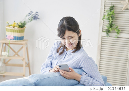 リビングでスマホを使う女性 リビングでスマホを使う女性 91324635