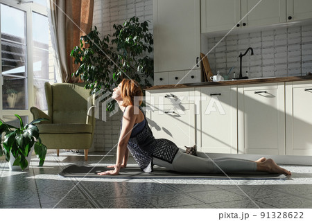 Middle aged woman practicing meditation at home, calm senior middle aged lady in lotus pose doing yoga for mental balance breathing air relaxing 91328622