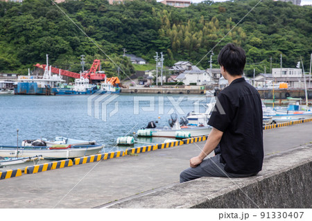 船着場で遠くを見つめる男性　Wharf 91330407