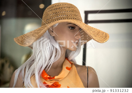 closeup of big summer hat and red dress on mannequin  in a fashion store showroom for women 91331232
