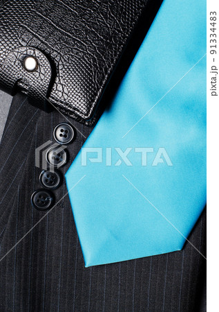 Blue men's necktie, jacket sleeve, and black wallet. Concept image of a successful business man 91334483