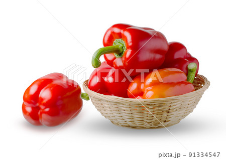 Paprika. Red bell peppers in a wicker basket. Isolated on a white background Paprika. Red bell peppers in a wicker basket. Isolated on a white background 91334547