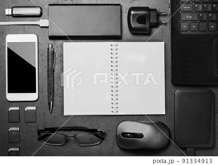Electronic gadgets, succulent flower and stationery accessories on a black concrete background. Copy space Electronic gadgets, succulent flower and stationery accessories on a black concrete background. Copy space 91334913