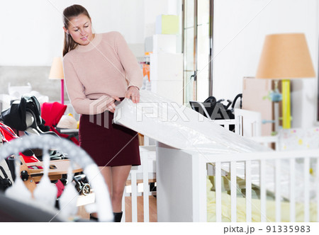 Woman consumer trying children's mattress Woman consumer trying children's mattress 91335983