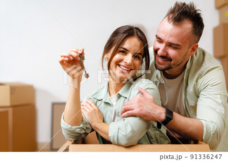 Young happy couple in room with moving boxes at new home Young happy couple in room with moving boxes at new home 91336247