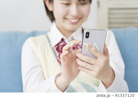 リビングでスマホを使う女子高生の手元のクローズアップ リビングでスマホを使う女子高生の手元のクローズアップ 91337120