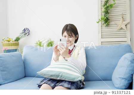 リビングでスマホを使う女子高生 91337121