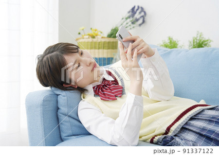 リビングでスマホを使う女子高生 91337122
