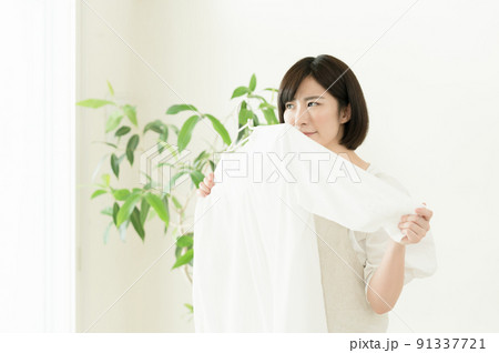 洗濯物の臭いを嗅ぐ女性 洗濯物の臭いを嗅ぐ女性 91337721