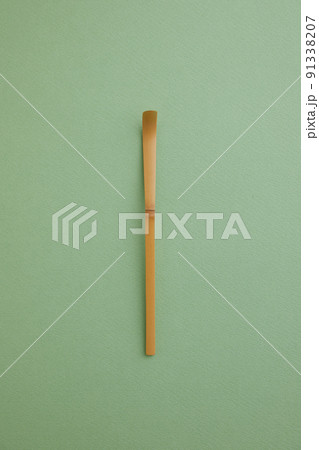 淡い緑のバックペーパーの上の茶杓 91338207