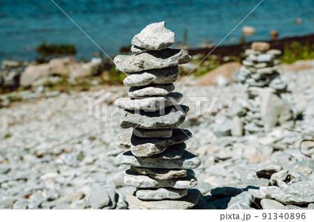 Stone figures on the beach of the Sorve Peninsula in the Ojessaare Nature Reserve. Estonia, Saaremaa. Horizon over sea in summer time. Pebble beach. 91340896
