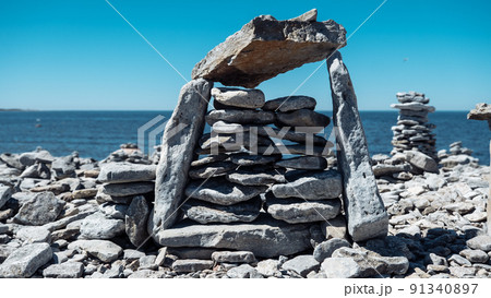 Stone figures on the beach of the Sorve Peninsula in the Ojessaare Nature Reserve. Estonia, Saaremaa. Horizon over sea in summer time. Pebble beach. 91340897