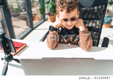 Schoolboy watches online video lessons on laptop. Studying during an epidemic Schoolboy watches online video lessons on laptop. Studying during an epidemic 91340987