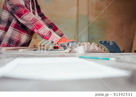 Carpenter cuts plywood on a circular saw. Carpenter cuts plywood on a circular saw. 91342531