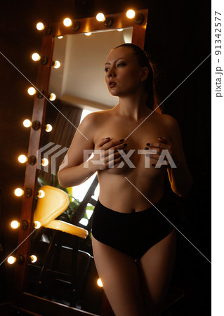 Alluring woman covering breast in studio Alluring woman covering breast in studio 91342577