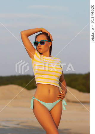Sexy model in crop top and bikini panties on beach Sexy model in crop top and bikini panties on beach 91344020