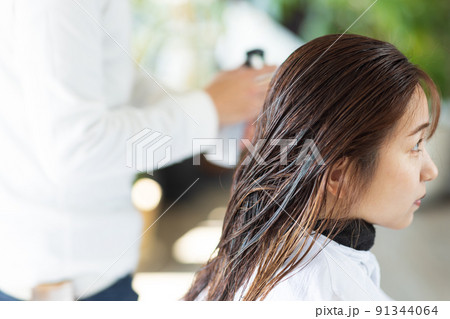 美容院でヘアカットしてもらう女性 91344064