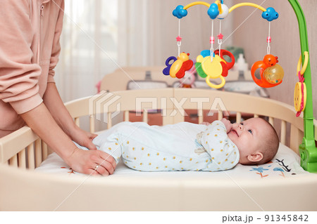 Baby massage. Mother doing gymnastics with newborn child Baby massage. Mother doing gymnastics with newborn child 91345842