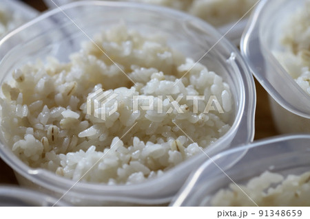 保存容器に小分けに入れた炊き立ての押し麦入りご飯 91348659