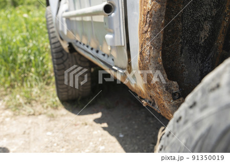 Rusty car body damaged by corrosion with hole on threshold 91350019