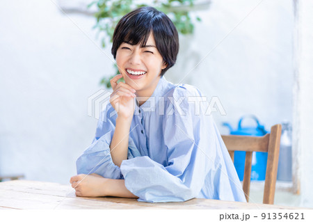 リビングでくつろぐ笑顔の若い女性 91354621