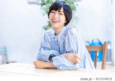 リビングでくつろぐ笑顔の若い女性 91354623