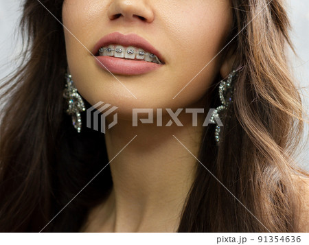 Close-up of sexy female lips with tongue. Clean skin and a clear lip contour are outlined with a fashionable pink lipstick. White teeth and the beauty of smile for stamotologii, spa or cosmetology 91354636