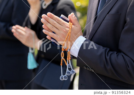 合掌する遺族 91356324