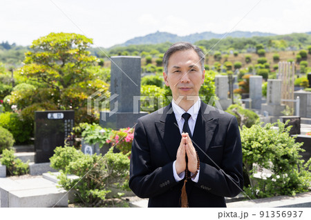 お墓参りをするミドル男性 91356937