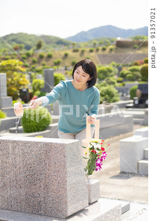 お墓を洗うミドル女性 91357021