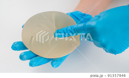 A plastic surgeon shows a breast silicone implant. A plastic surgeon shows a breast silicone implant. 91357946