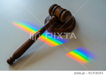 Judicial gavel on a table with a rainbow light prism.  91358265