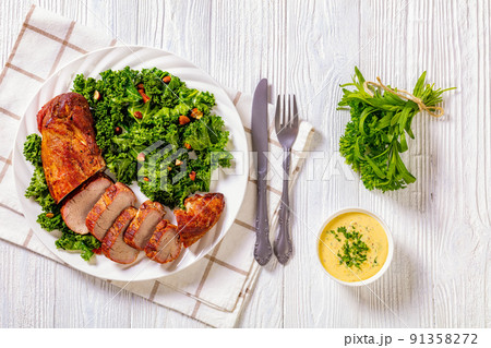 Roast Pork Tenderloin with kale salad on plate 91358272
