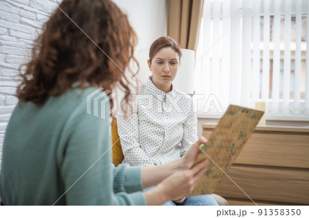 Worried caucasian woman at a session with a psychotherapist.  91358350