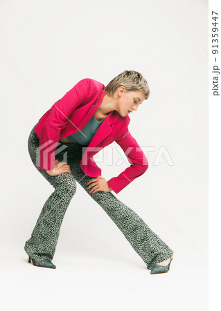 Portrait of young extravagant stylish girl in bright pink jacket posing isolated over white studio background 91359447