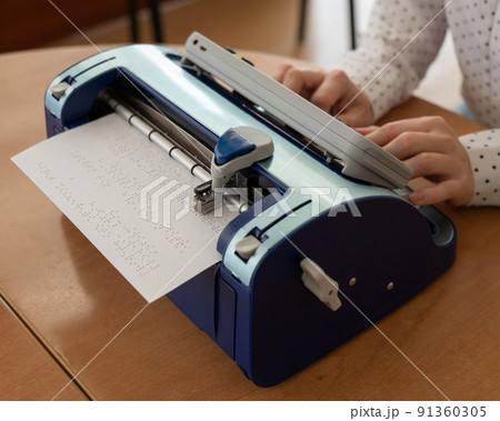 Blind woman using braille typewriter.  91360305