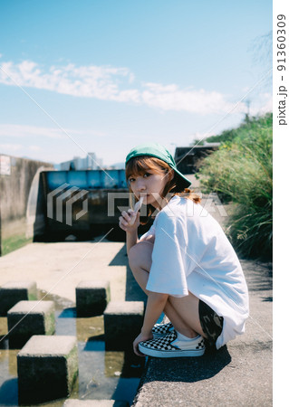 河川敷でアイスを食べる女の子 91360309