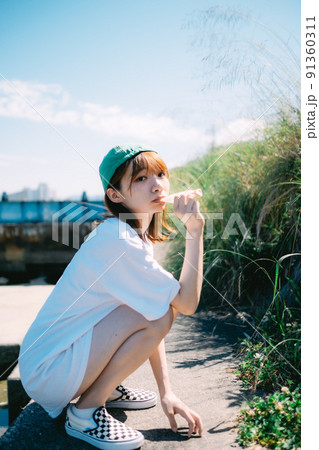 河川敷でアイスを食べる女の子 91360311