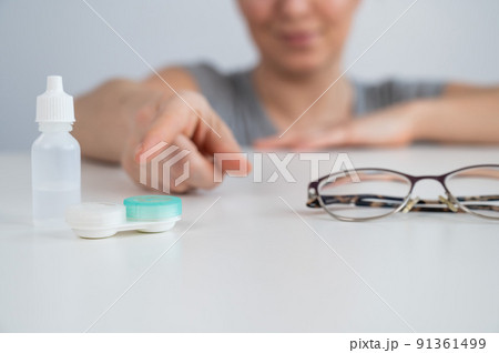 Caucasian woman prefers contact lenses to glasses.  91361499