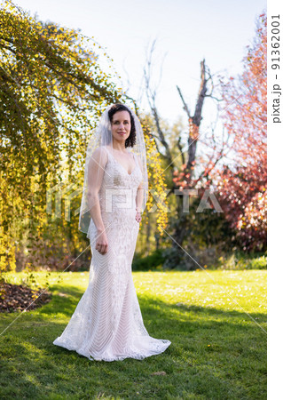 White Caucasian Adult Woman in a Wedding Dress standing outside in nature White Caucasian Adult Woman in a Wedding Dress standing outside in nature 91362001