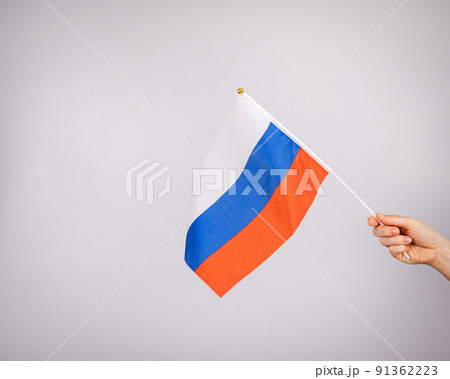 Woman holding a small flag of the Russian Federation on a white background. Woman holding a small flag of the Russian Federation on a white background. 91362223