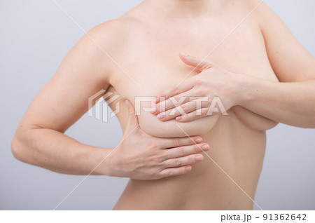 Caucasian woman self checks for breast cancer on white background.  91362642