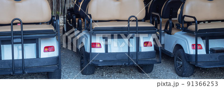 Three identical recreational electric cars are parked on a gravel path in the park. Selective focus 91366253